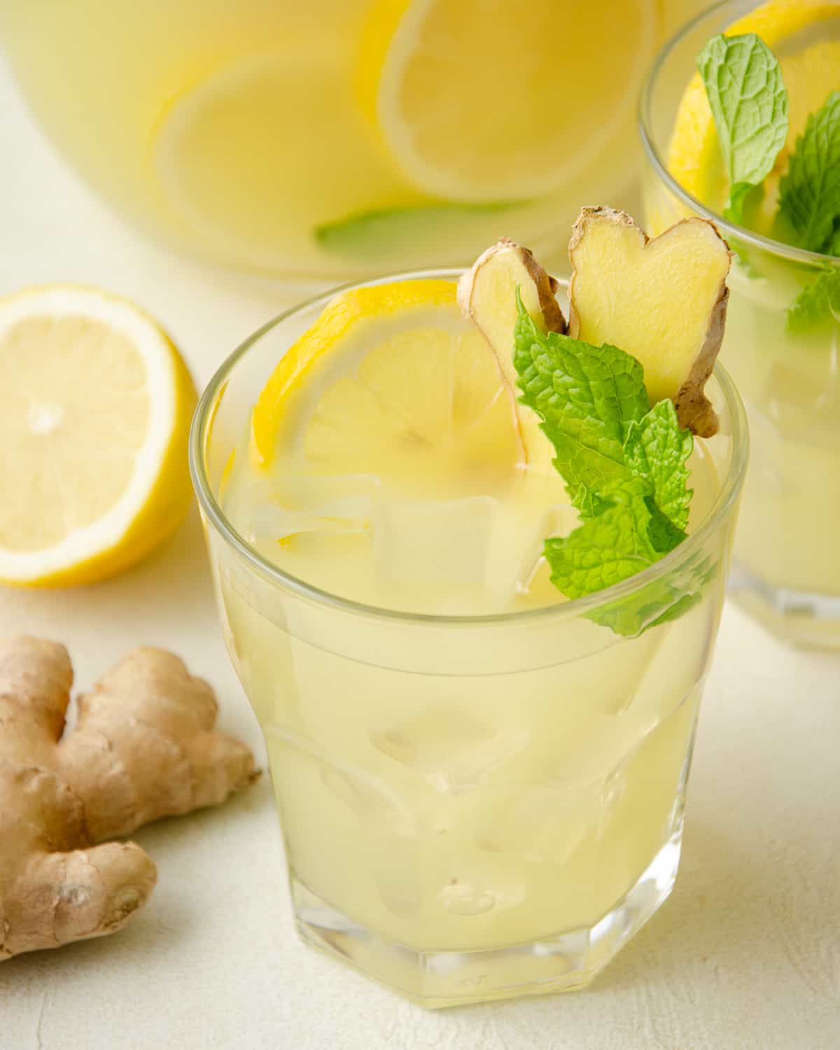 Ginger-Lemonade-Lemonade-In-Glass-With-Pitcher-Behind